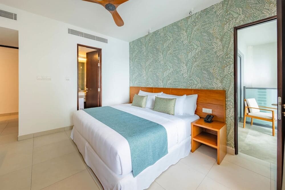 Guest room at Barceló Nasandhura Malé with a teal runner and botanical feature wall
