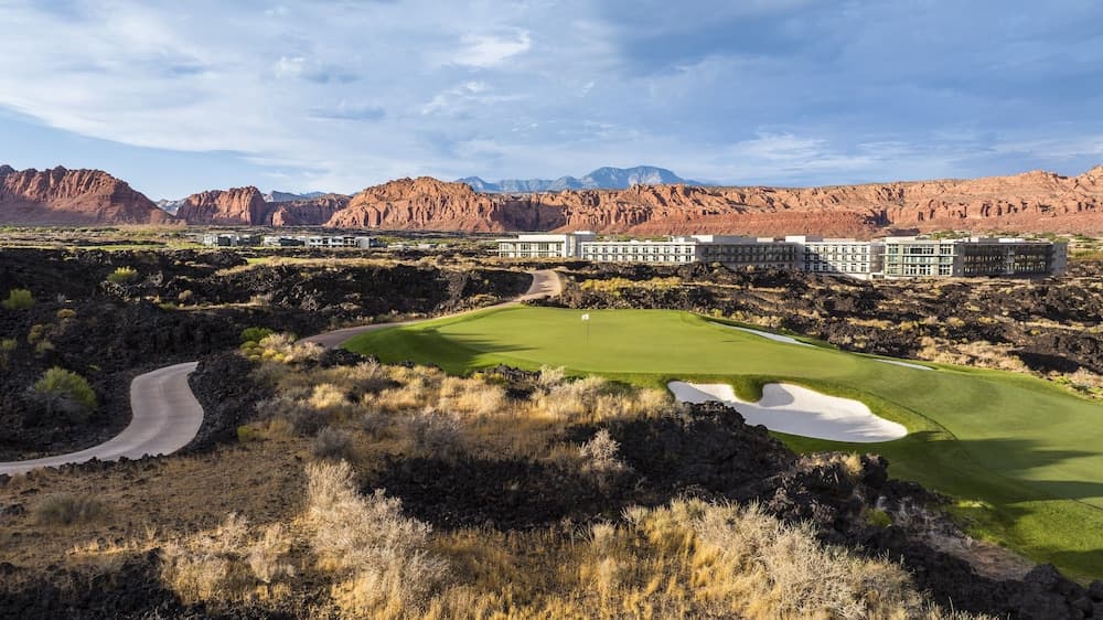 Aerial view of Black Desert Resort showing the Tom Weiskopf golf course threading between black lava fields and red rock cliffs
