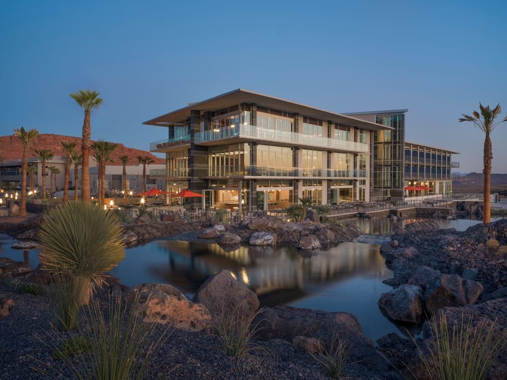 Black Desert Resort exterior at dusk — Ivins, Utah, with red rock backdrop and palm trees