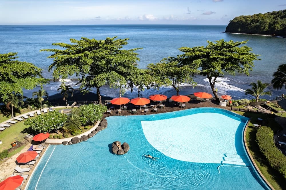 Le Tahiti by Pearl Resorts beachfront pool overlooking Papeete lagoon at sunset